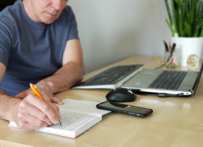 Man is writing in the journal