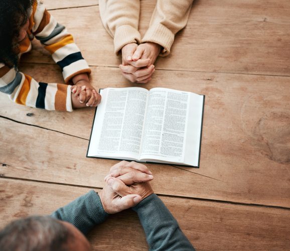 Bible, reading book or hands of grandma with children for worship, support or hope in Christianity